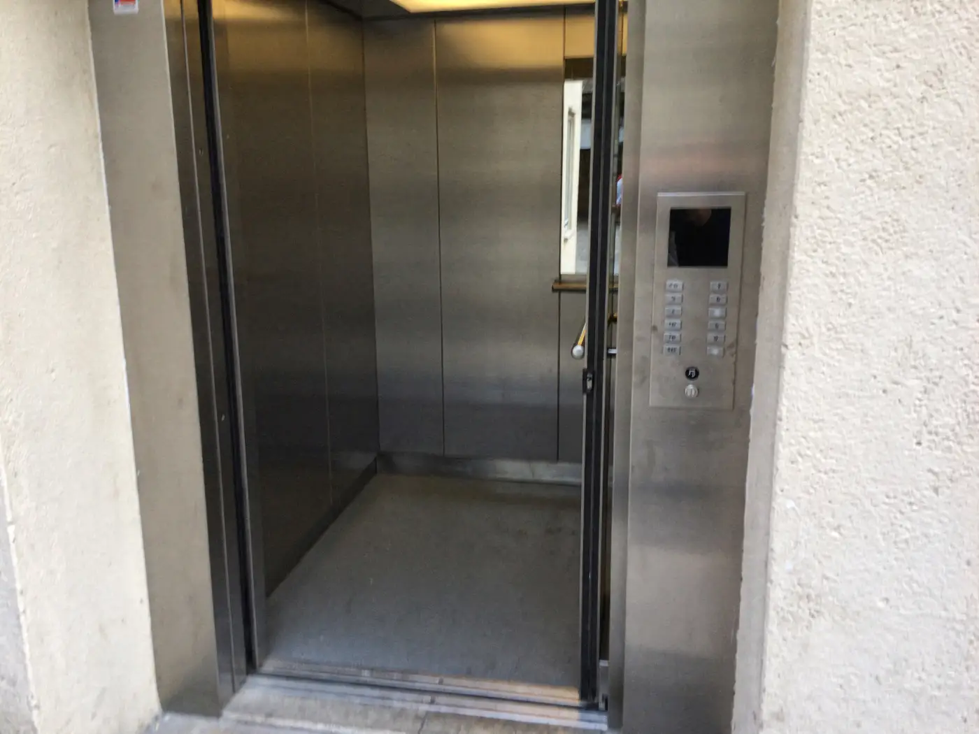 Cabine d'ascenseur propre dans un immeuble à Lyon, miroir et boutons nettoyés